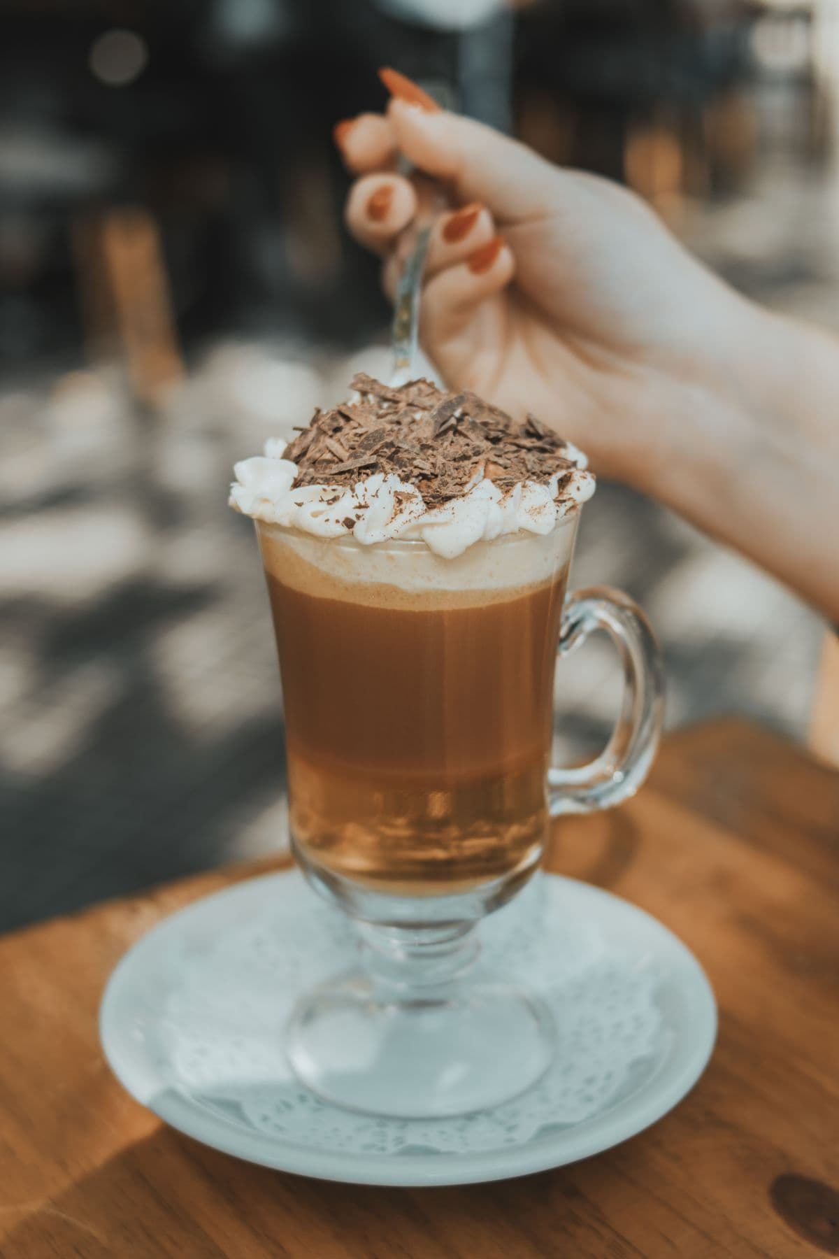 Pouring strong coffee into a glass of ice before adding the salted cream layer