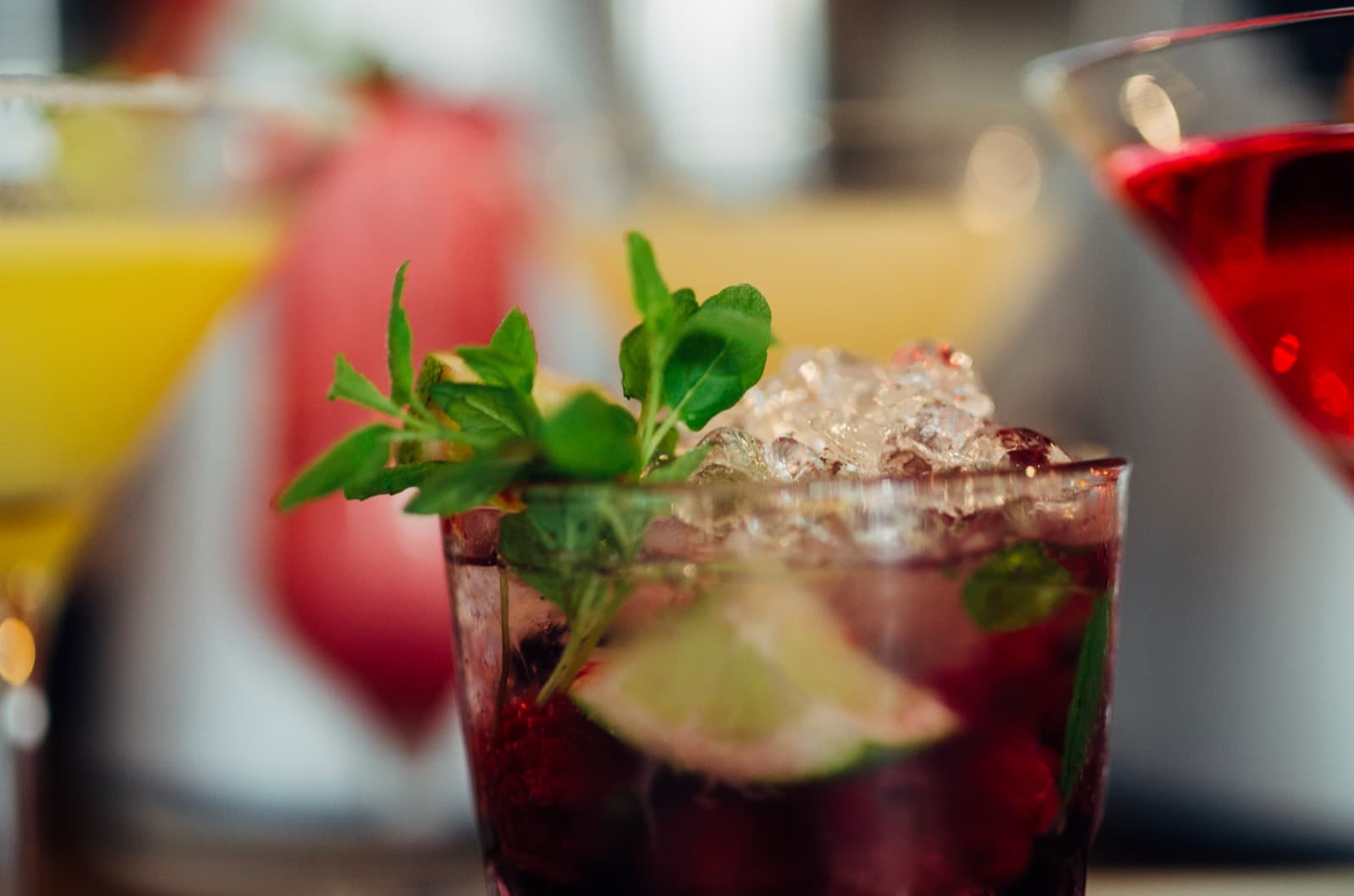 Các ly đồ uống nhiều màu cùng nguyên liệu tươi bày trên mặt quầy bar