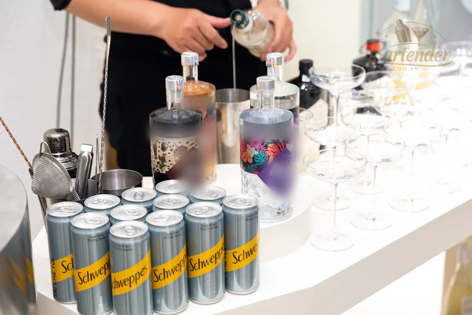 Bartender rót hoàn thiện ly cocktail tại quầy