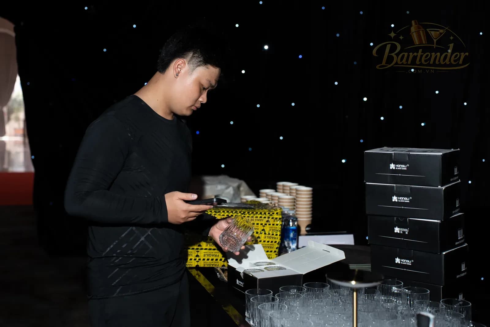 Bartender mở thùng ly pha lê chuẩn bị cho quầy