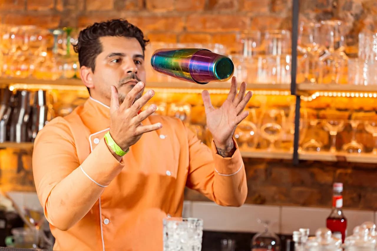 Bartender trình diễn kỹ thuật flair với bình lắc tại quầy bar